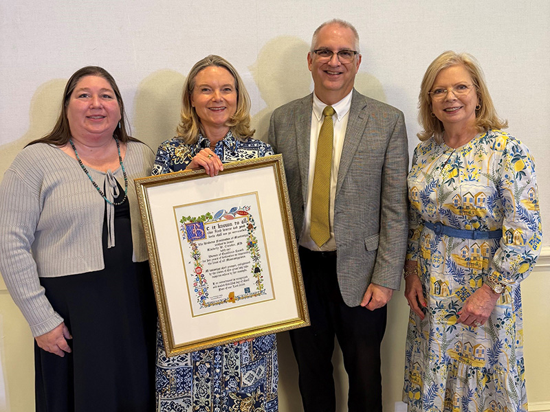 Dr Kimberly Croeder, second from the left, poses with her award among three members of the Department of Ppthalmology.